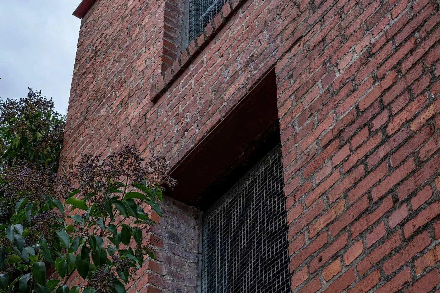 Aging brick chimney with deteriorated mortar joints and spalling bricks