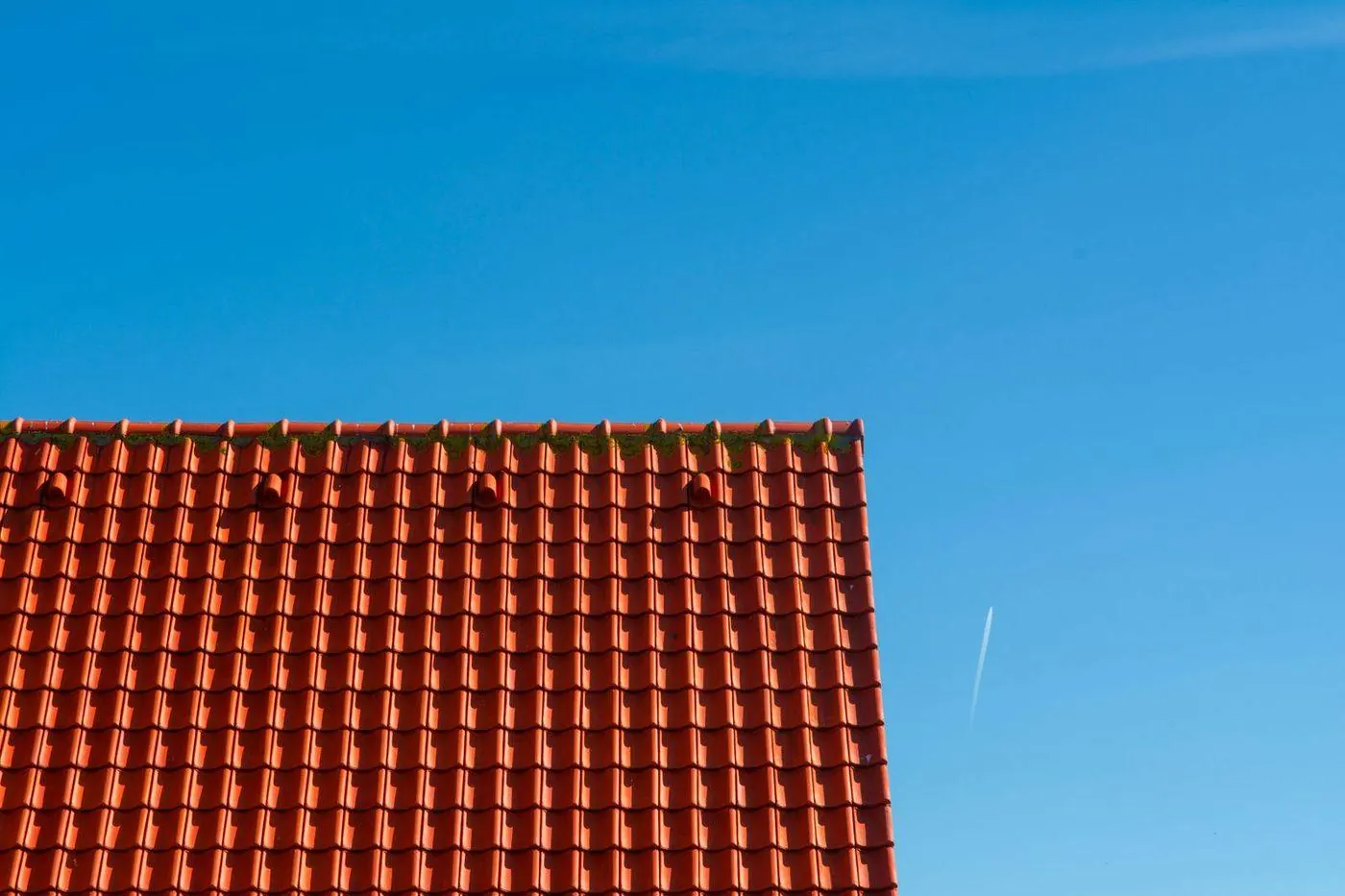 Shingle roof on a house near the water under wind-blown clouds