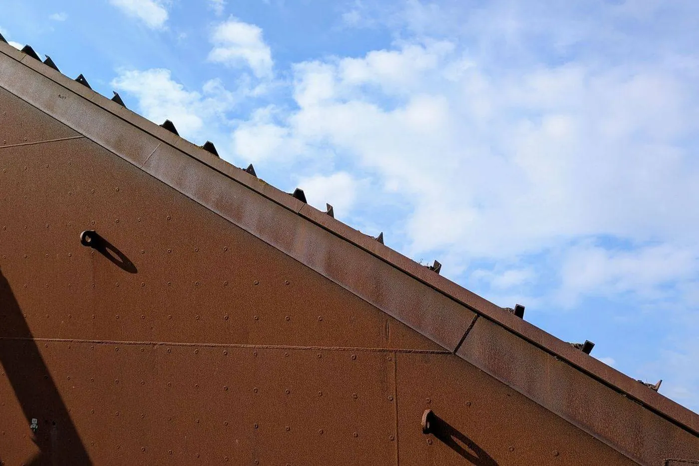 Corroded rusted roof flashing with cracked sealant and a gap