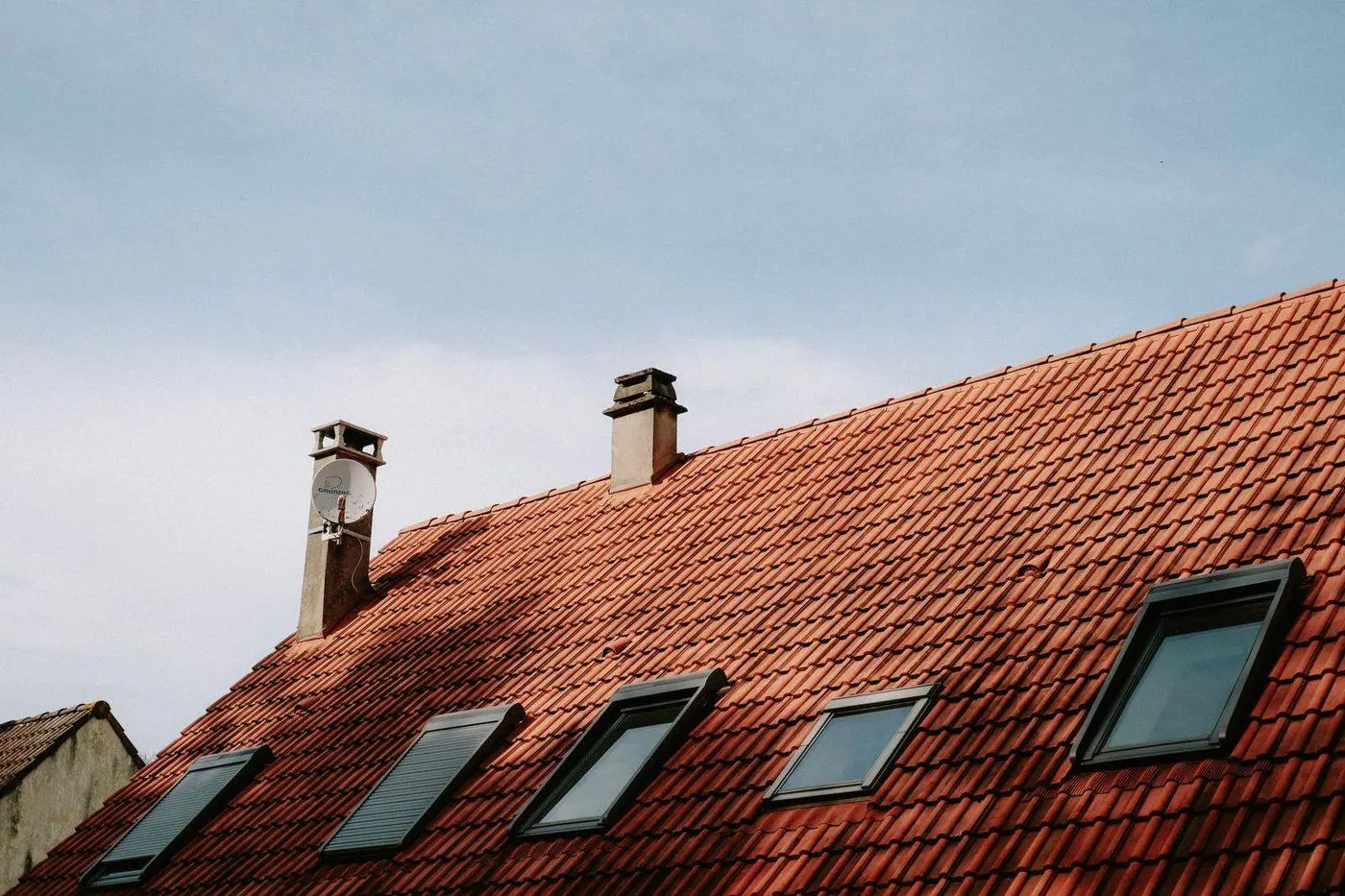 Skylight set into a shingle roof with metal flashing around its curb