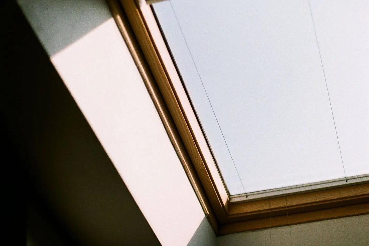 Close-up of aged cracked sealant along a skylight curb flashing edge
